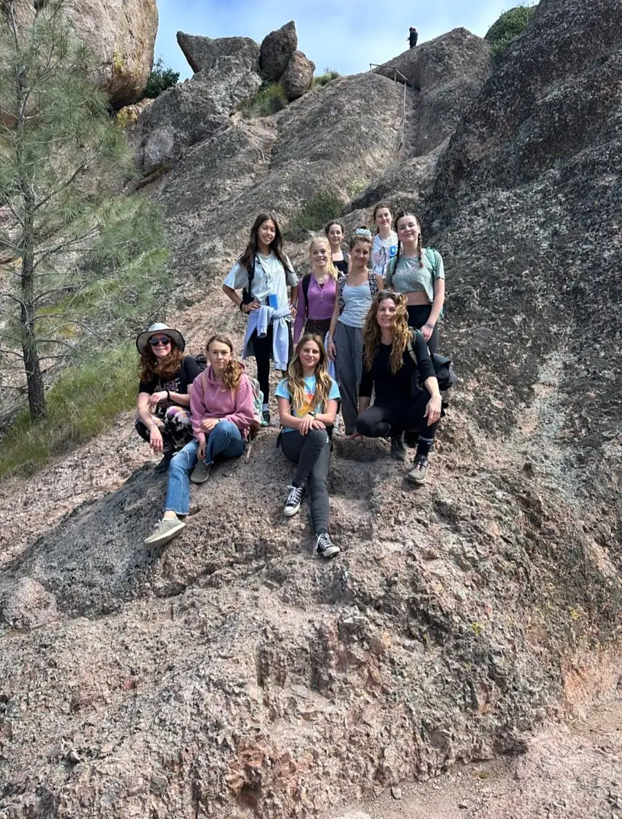 Girls and mentors resting together on high granite rocks